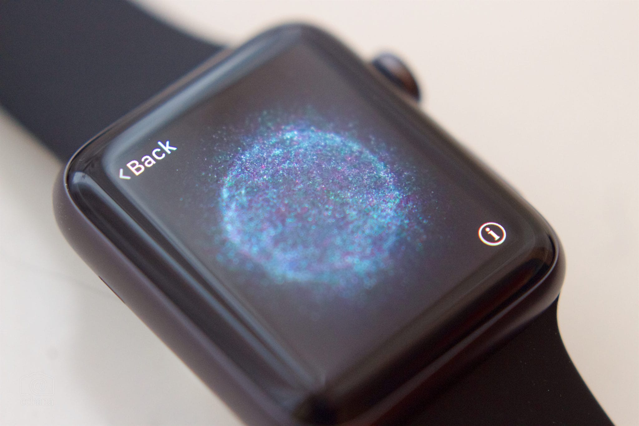 A smartwatch displaying a galaxy image on its screen, with a "back" button visible in the upper left corner.