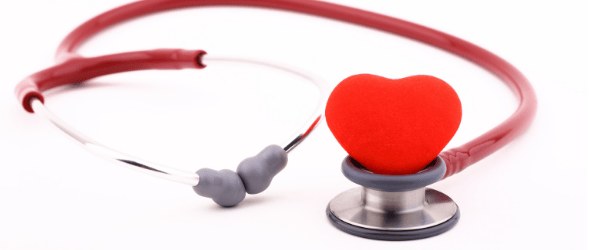 Red stethoscope with a heart-shaped object at its center, lying on a white background.