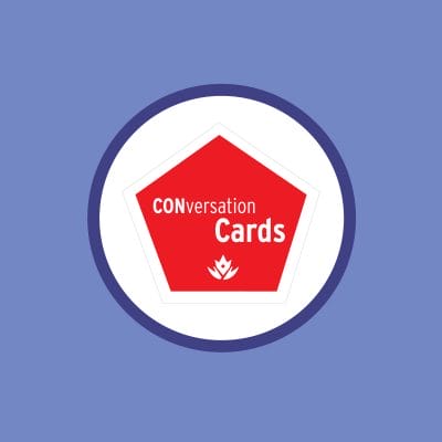 Logo of "conversation cards" featuring a red pentagon with white text and a small white flame at the bottom, set against a blue background.